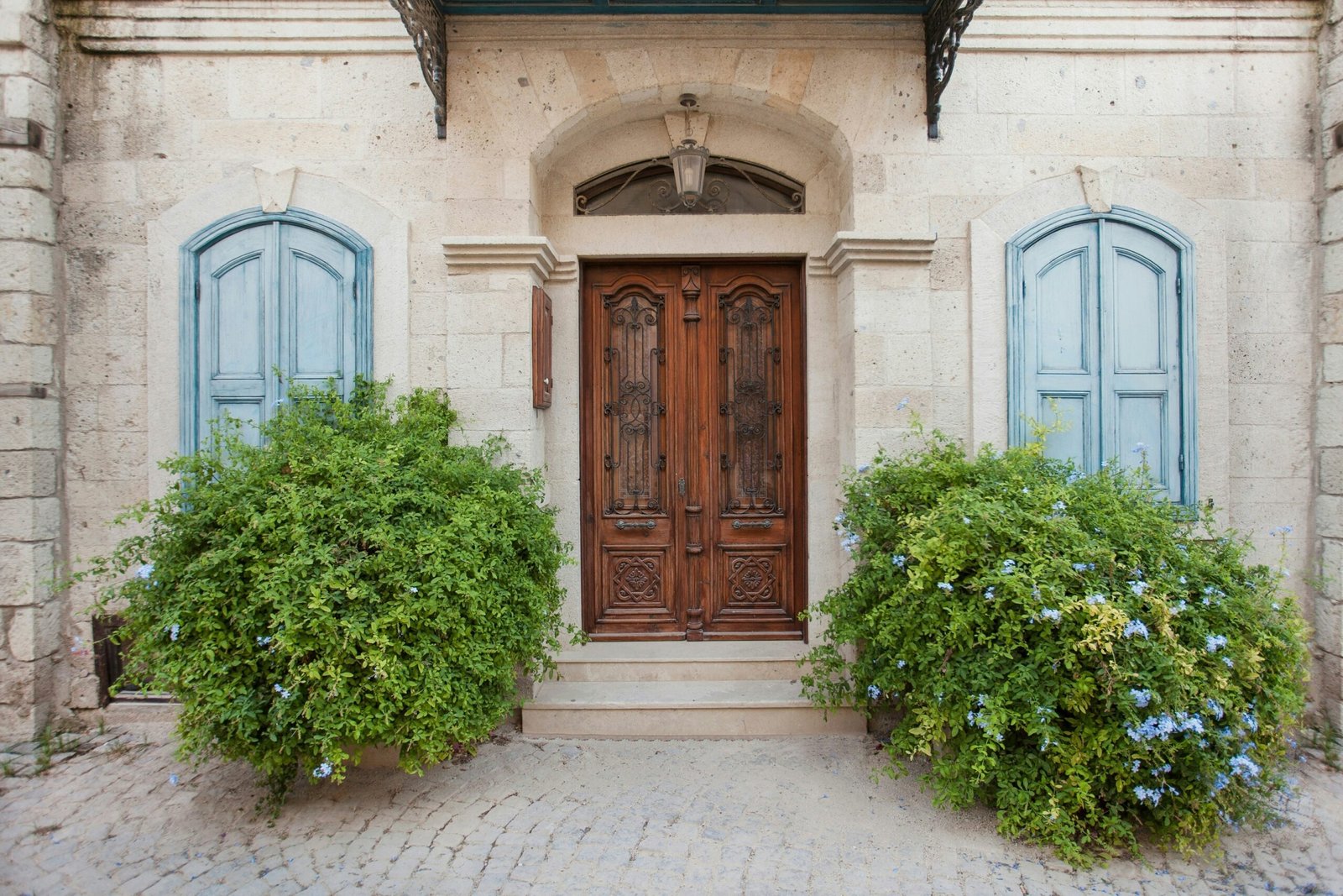 brown wooden door on white concrete building